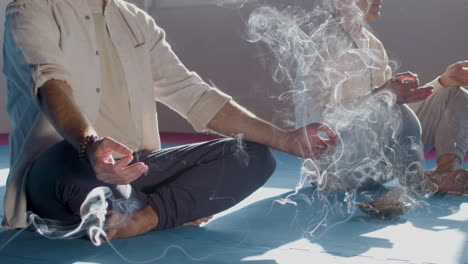 Men-sitting-in-lotus-position-and-meditating-with-incense