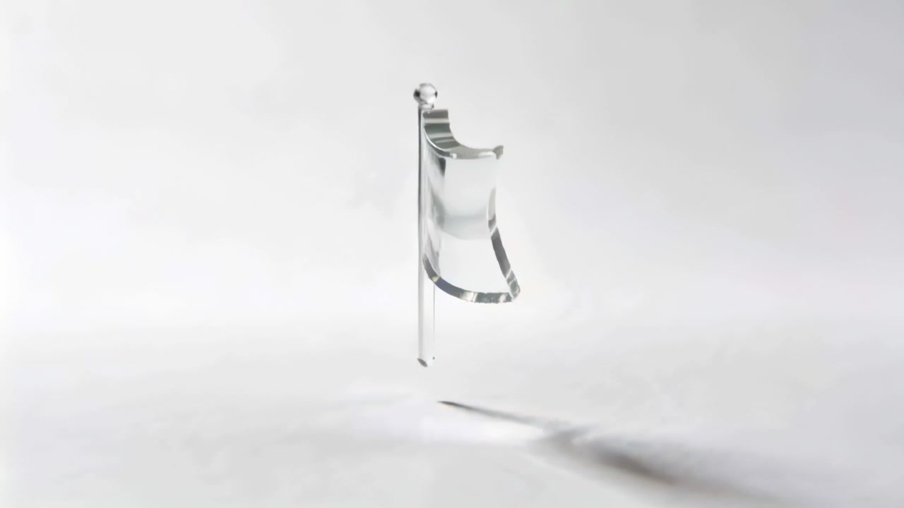Rotating glass flag on pole with finial above white floor in studio, frames revealing highlights