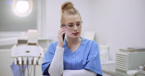 Female-Doctor-Talking-On-Mobile-Phone-At-Healthcare-Clinic-2