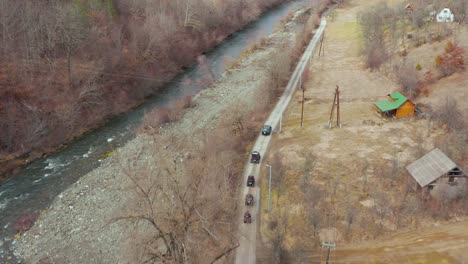 All-terrain-Vehicle-Driving-On-Dirt-Road-Along-Mountain-River