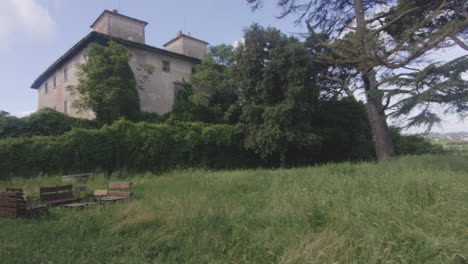 wooden seats on grass outside villa gaidamachuk in florence, italy