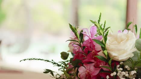 a close-up of a colorful flower arrangement with a blurred natural background, captured in soft lighting
