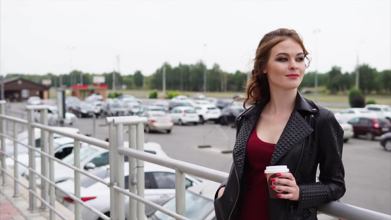 Ragazza con caffè in un parcheggio