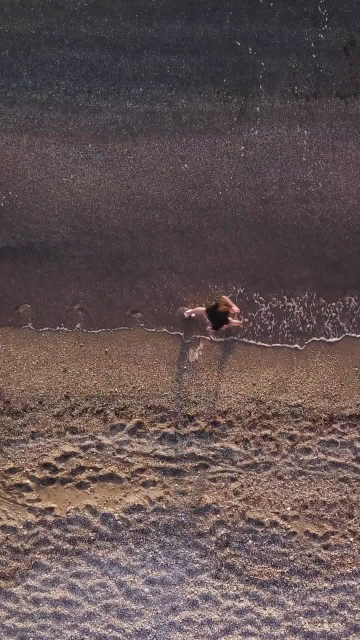 Young man running at shore alone. Top view, Aerial view