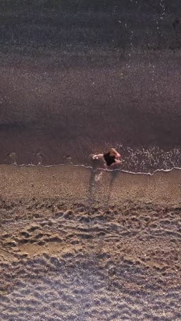 young man running at shore alone. top view, aerial view