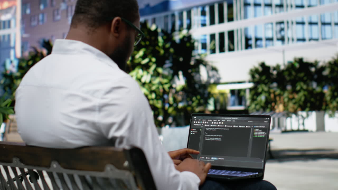 African american guy works on programming code on terminal window