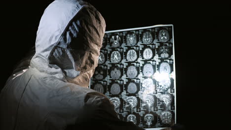 doctor in protective clothing looks at the results of the patient's examination