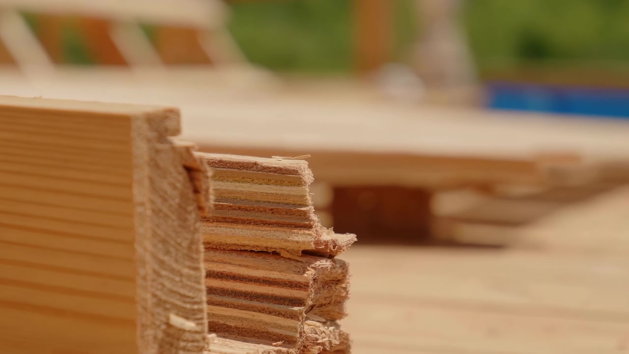 Panca in legno in una scena statica all'aperto, con vegetazione e un tavolo, ripresa da un punto di vista fisso e leggermente elevato.