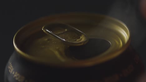 close up of pulling ring pull on can of irish stout to celebrate st patricks day