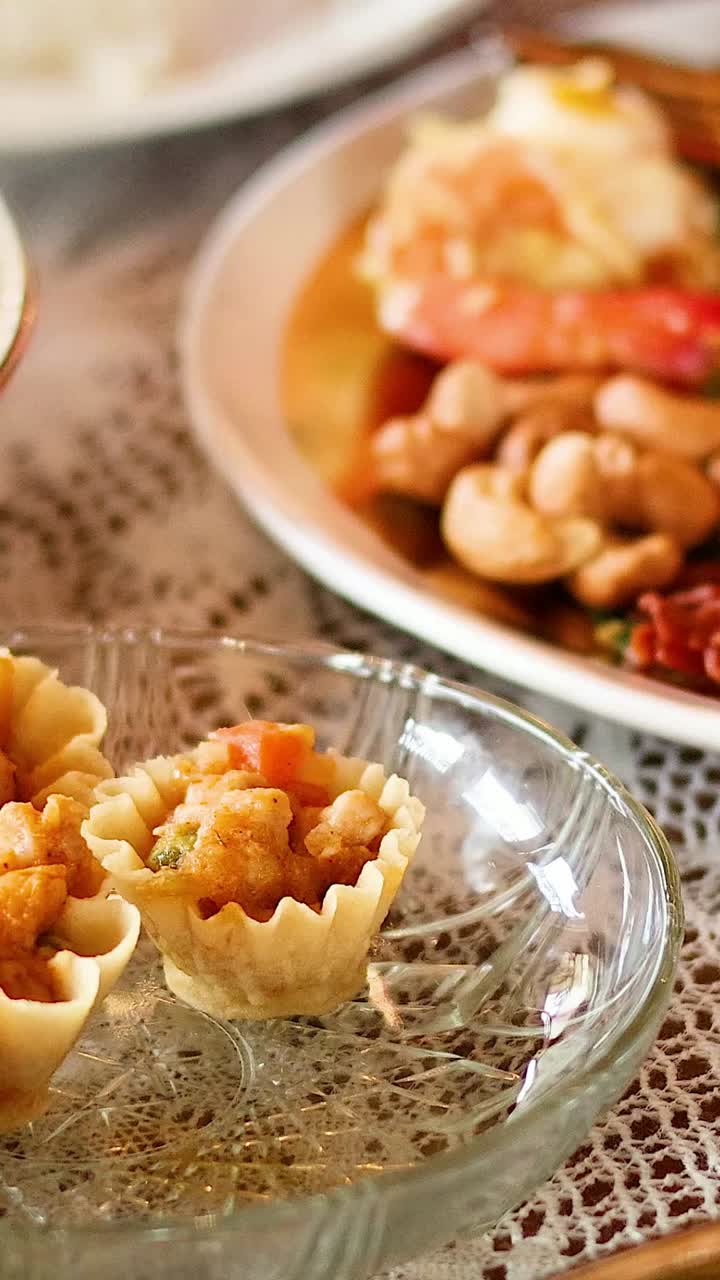 la mano sirviendo tortillas tailandesas en una mesa de comedor