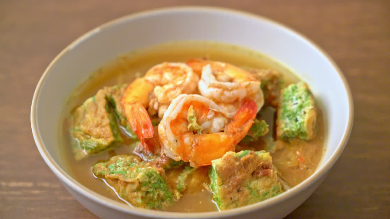 sopa agria hecha de pasta de tamarindo con gambas y tortilla de verduras - estilo de comida asiática