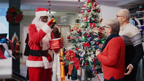 Employee-in-xmas-adorn-fashion-boutique-wearing-Santa-Claus-costume-and-customers-gathered-around-beautifully-decorated-Christmas-tree-in-clothing-store-during-winter-holiday-season