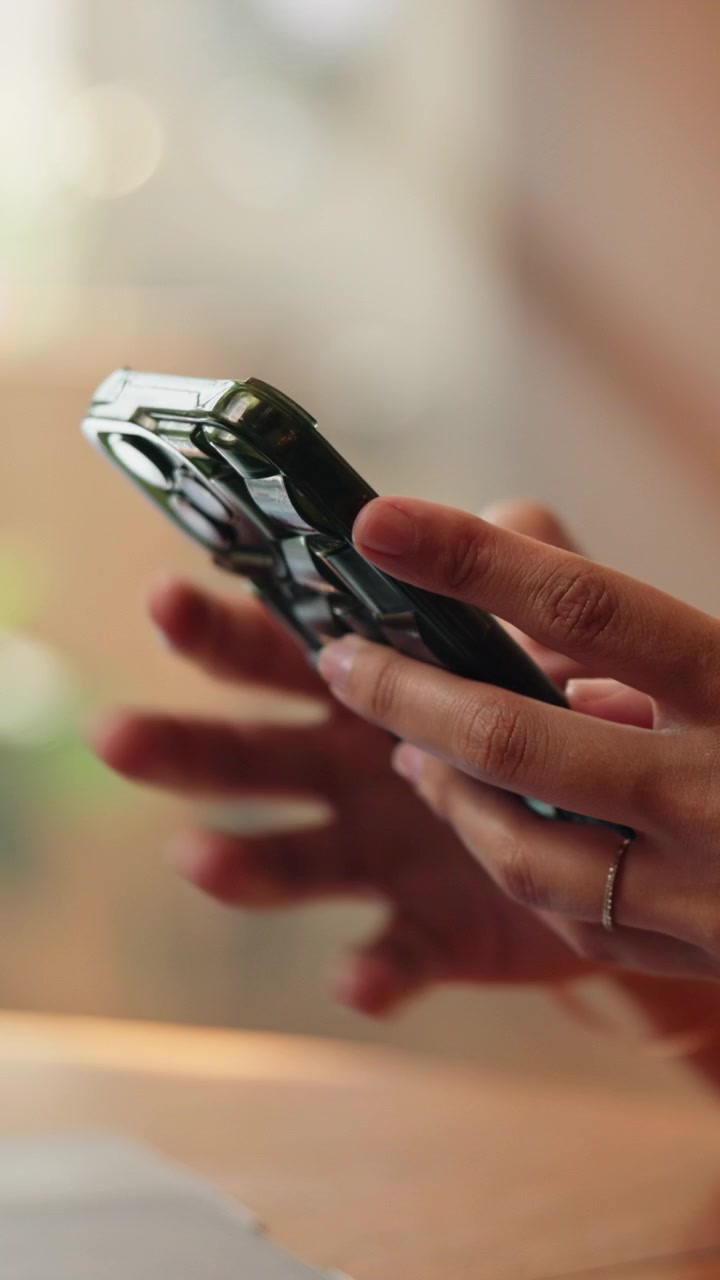 Primo piano di una persona che usa lo smartphone al bar