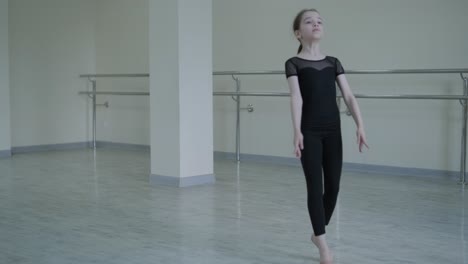 young ballerina practicing dance moves in studio