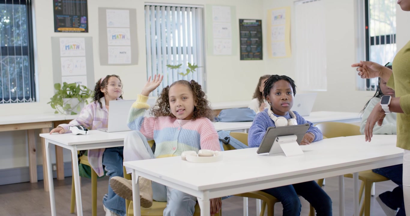 Camarades de classe préadolescents observant pendant que l'instructeur interroge les élèves, deux filles marchant avec une tablette