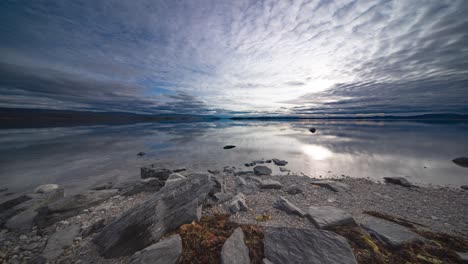 Während-Die-Flut-Langsam-Steigt,-Ziehen-Stürmische-Wolken-Schnell-Vorbei-Und-Spiegeln-Sich-Auf-Der-Spiegelähnlichen-Oberfläche-Des-Fjords,-Festgehalten-In-Einem-Zeitraffervideo