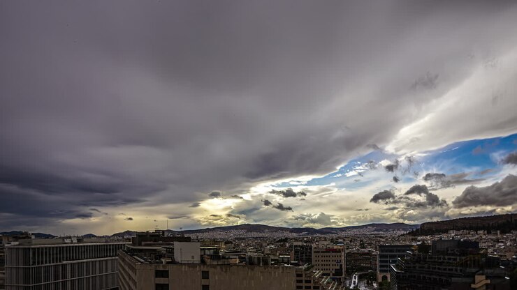Timelapse shot of cloud movement over city houses in Akropole, Athens, Greece on a cloudy day