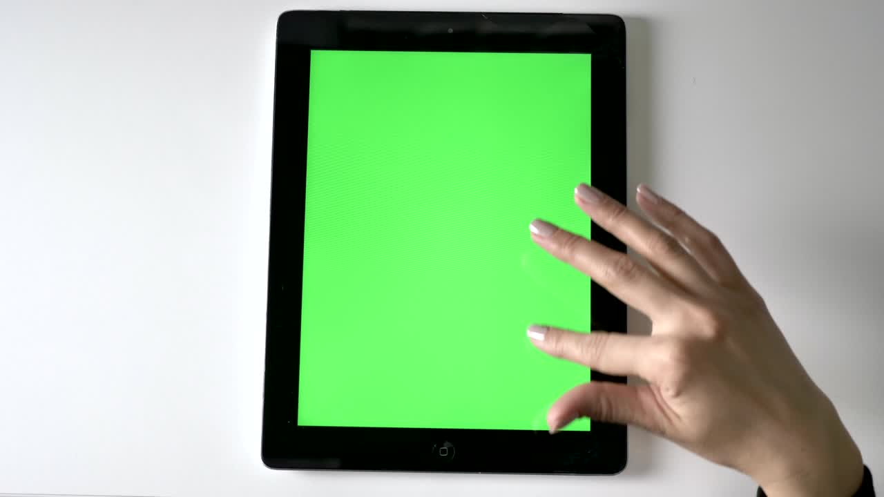 Female hand scrolling on tablet. Green screen, chromakey concept, Top shot 60 fps