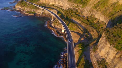 Vehículos-Que-Circulan-Por-El-Puente-Del-Acantilado-Marino-En-Un-Día-Soleado-En-Clifton,-Australia