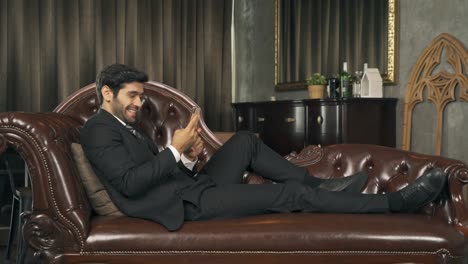 smiling business middle east man, ceo person working from home, and using a mobile smartphone to text message in technology device communication concept.