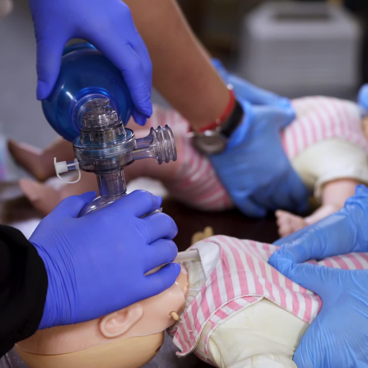 Practice of chest compression on dolls. Students teaching cardiopulmonology procedure for giving first aid on a mannequin in medical center. Close-up