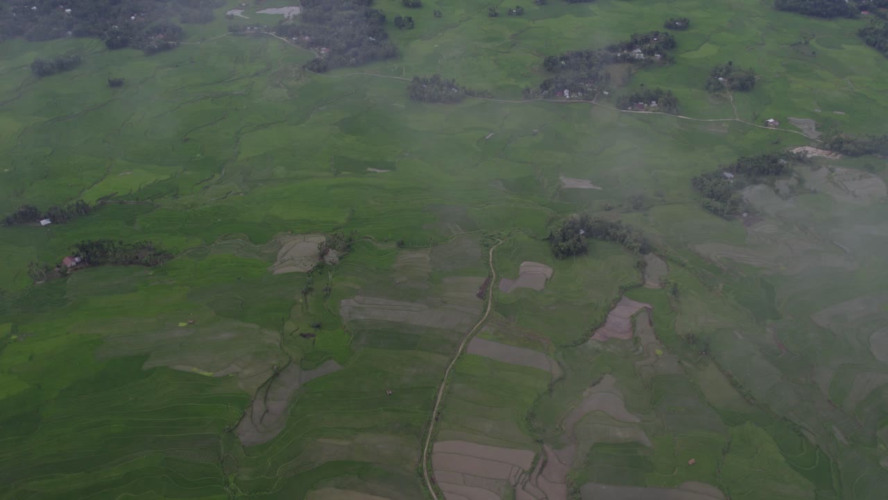 fotografía de campos de arroz verdes con nubes bajas en la isla de sumba, desde el aire