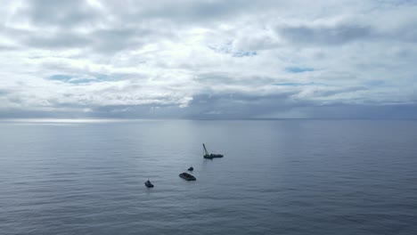 large floating water crane installing a new artificial reef structure deep in the ocean