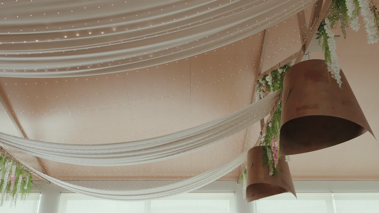 Decoración elegante de techo para bodas con cortinas de tela y flores