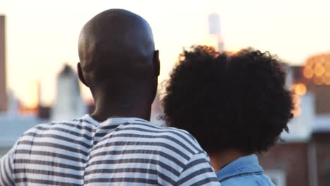 Young-black-couple-enjoying-the-view-from-rooftop,-back-view