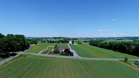 An-Aerial-View-of-the-Farm-Countryside-With-Planted-Fields-and-a-Single-Rail-Road-Track-on-a-Curve-on-a-Beautiful-Sunny-Day