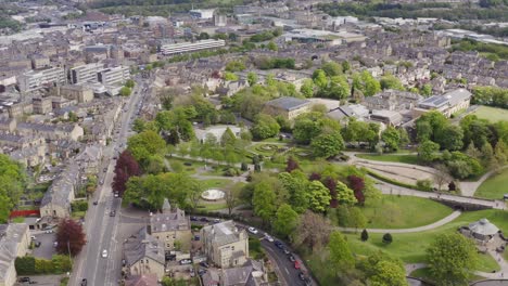 aerial shot flying over british town with houses and woodland in yorkshire