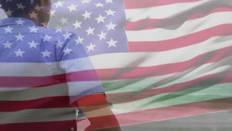 Animation-of-biracial-man-in-wheelchair-by-sea-over-flag-of-usa