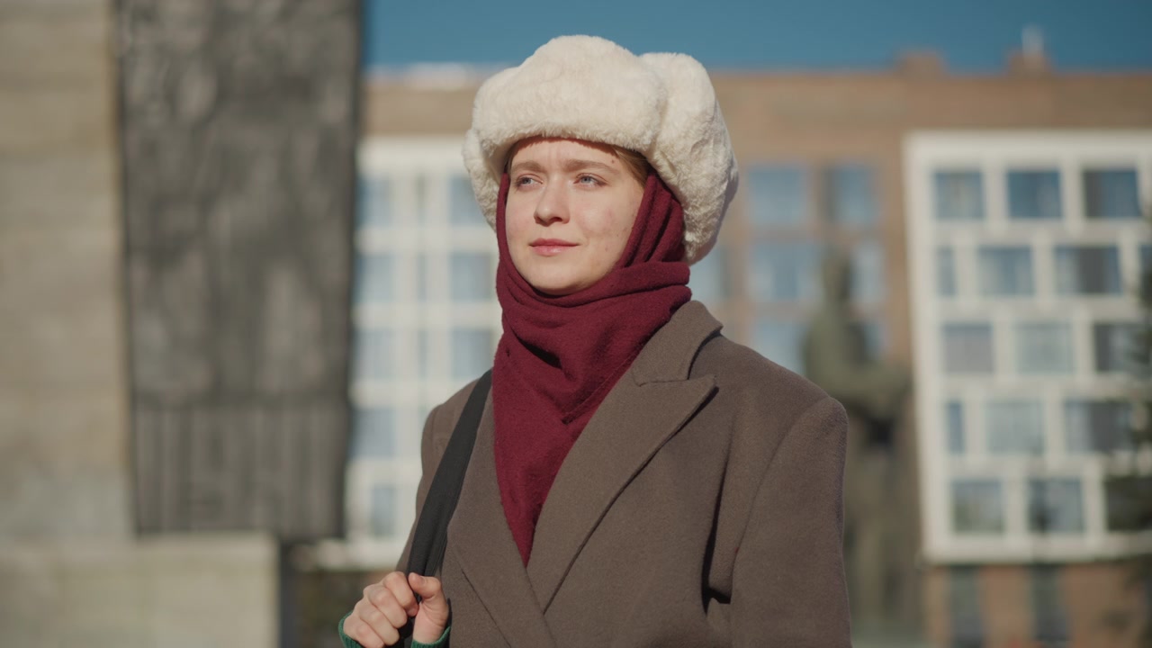 Giovane donna che indossa cappello e cappotto invernali in piedi all'aperto