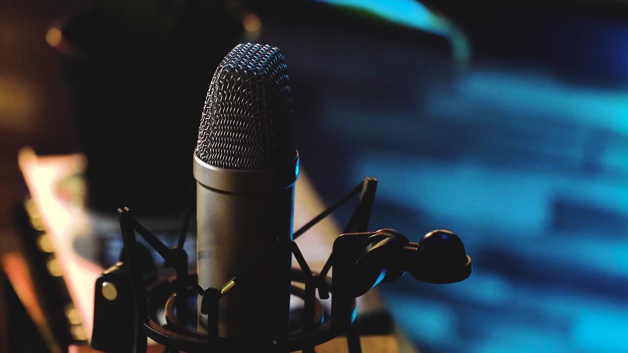 un micrófono se enfoca y el contraste entre la luz azul y cálida se ilumina