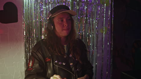 skilled dj enjoying music mixing at club neon lights wearing headphones closeup
