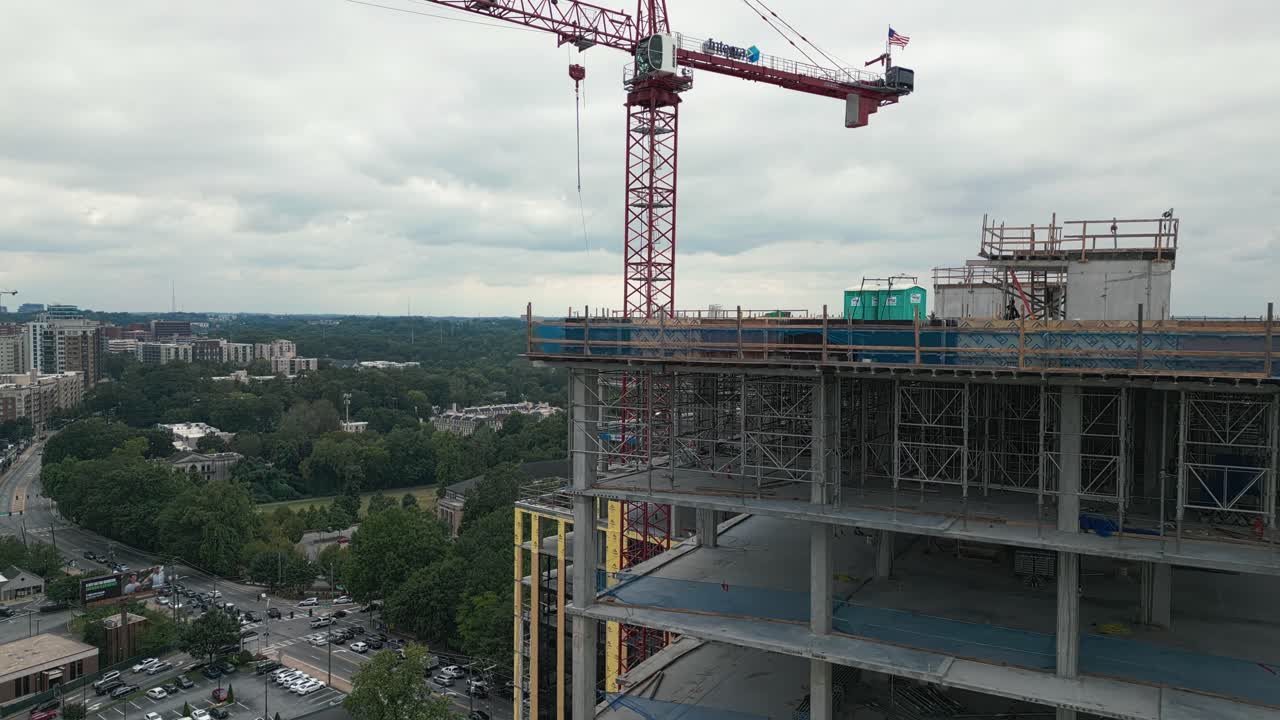 tomada de drone descendiendo que muestra la grúa y el encuadre del edificio de la torre en la ciudad de atlanta