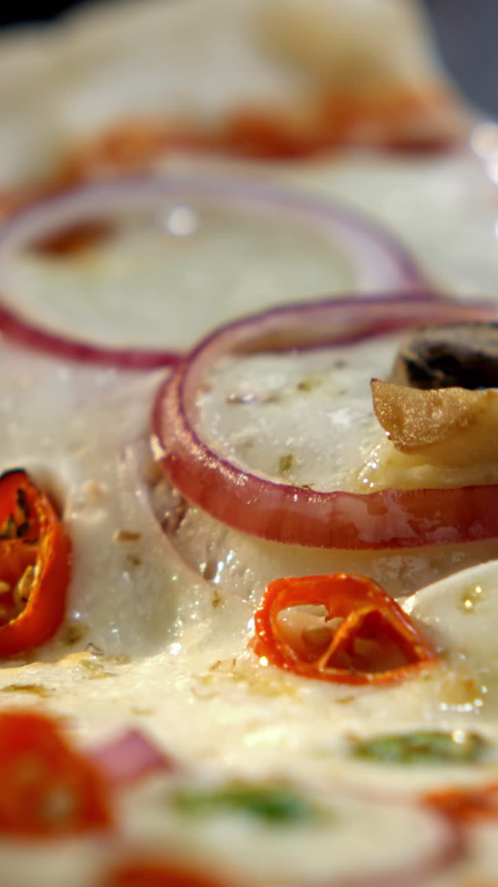Close-up of a cheesy pizza with tomatoes and red onion