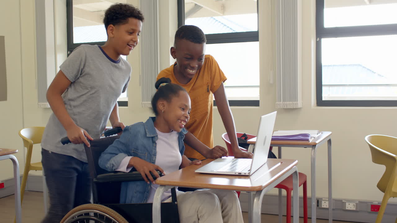 Multiracial students using on laptop in classroom, smiling and engaged in learning, at school