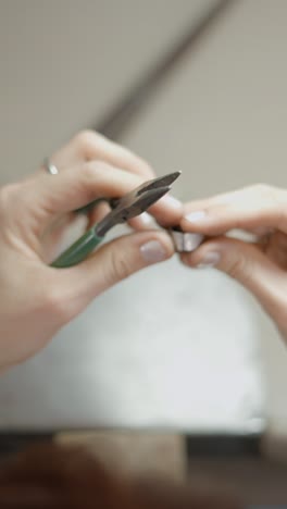 close-up of hands using pliers for crafting or jewelry making