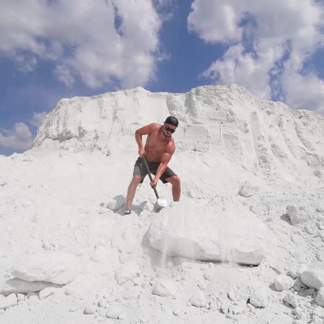 man hitting stone with hammer