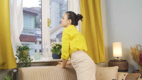 The-young-woman-opens-the-closed-curtains-in-her-house.