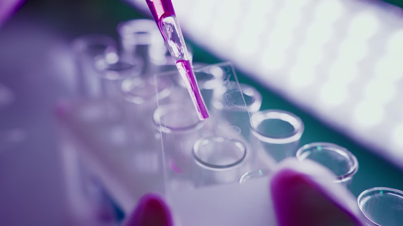 Close-Up of Pipette Dispensing Liquid onto Microscope Slide in Lab