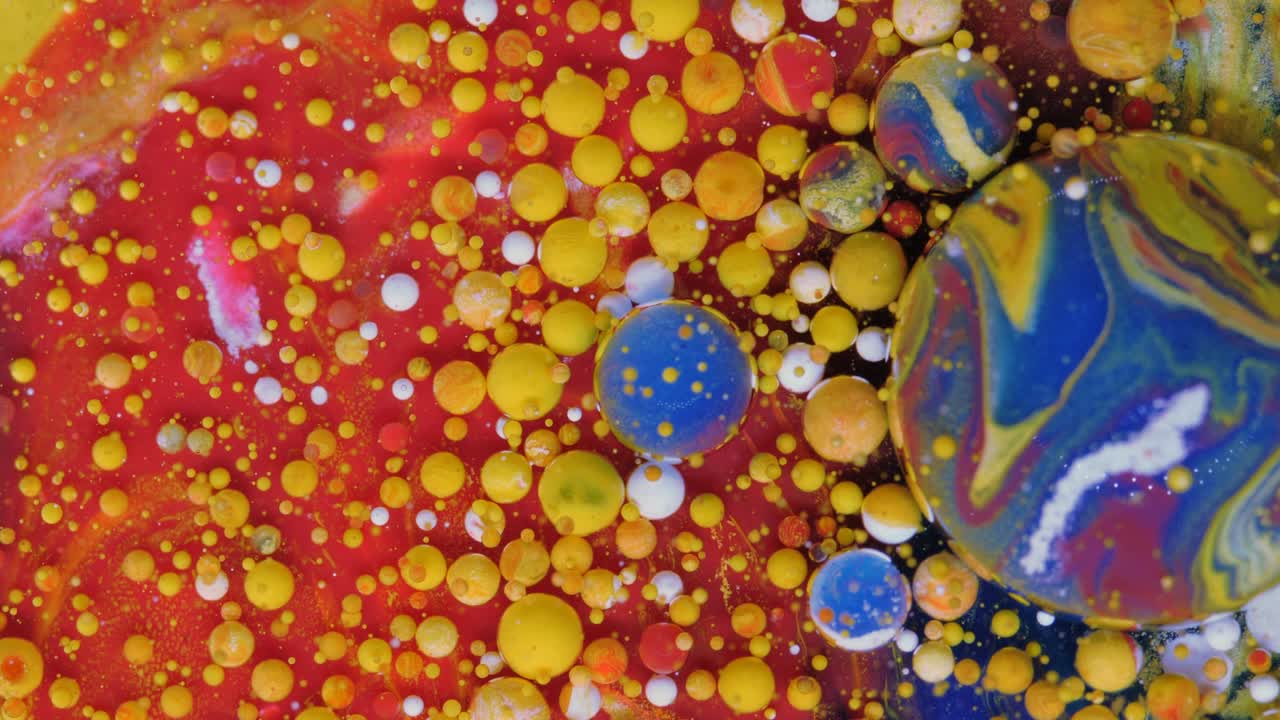 burbujas rojas, azules y amarillo-doradas sobre un fondo rojo.