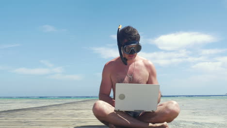 busy man in snorkel and mask with laptop