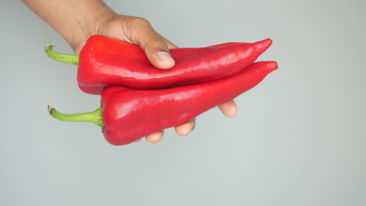 Hand holding red bell peppers