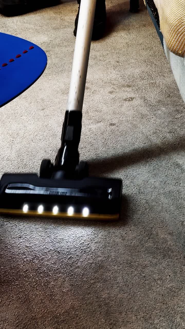 Vysavač s LED světly čistící koberec.