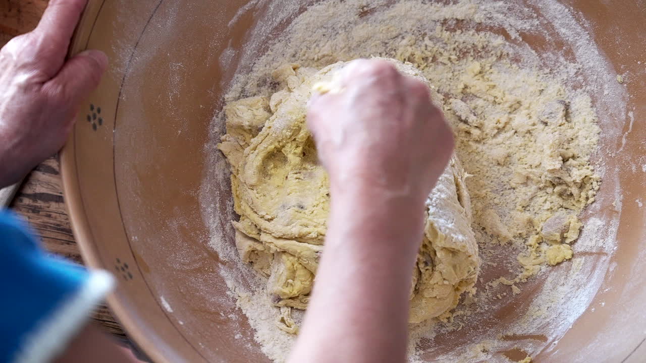 Elderly Woman baking and kneading biscuit dough in kitchen , top view