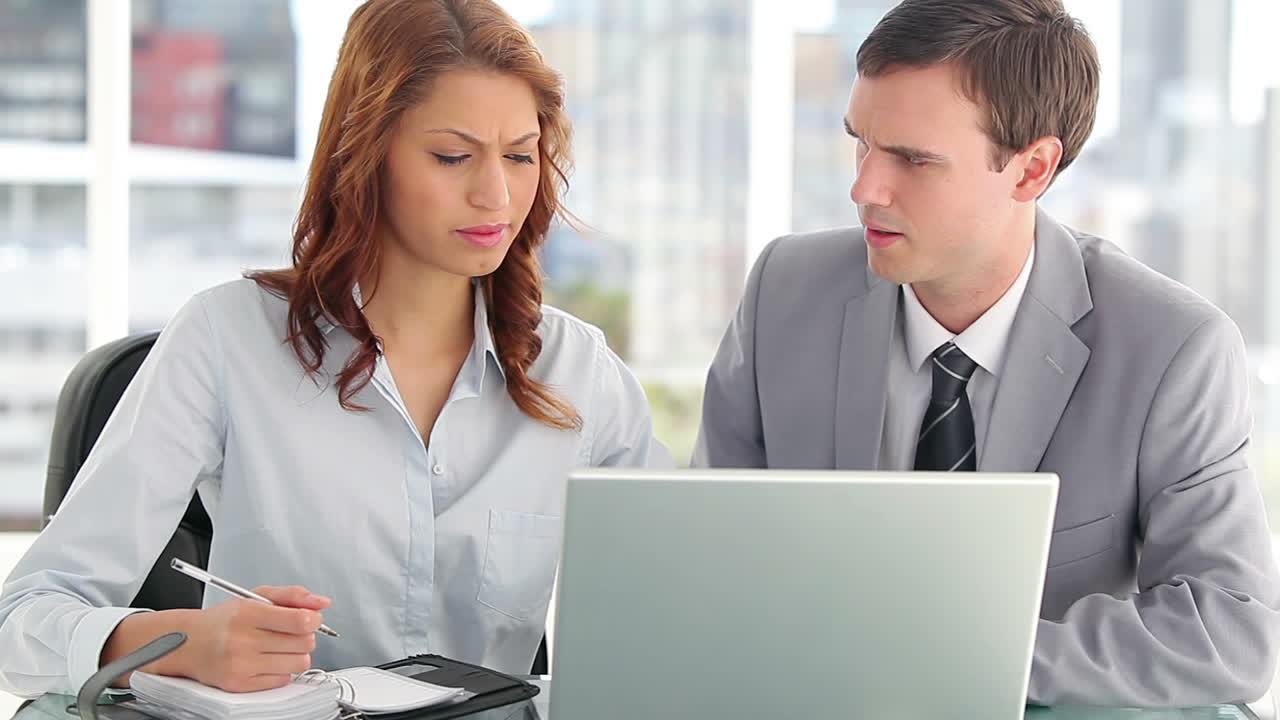 Colleghi seri che lavorano insieme su un laptop