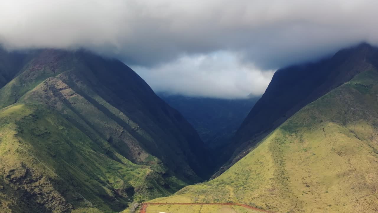 panorámica aérea para revelar la profundidad de un hermoso valle seco impresionante con nubes oscuras por encima