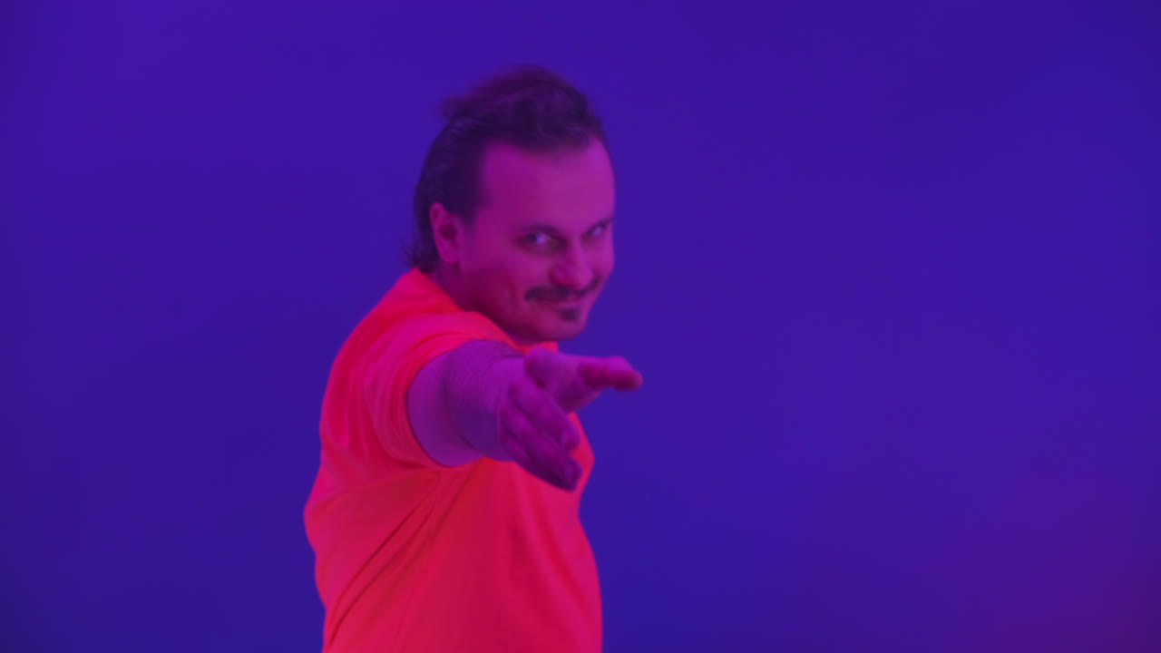 hombre loco bailando a la luz del neón de la danza ridícula. hombre gracioso en un fondo azul de color